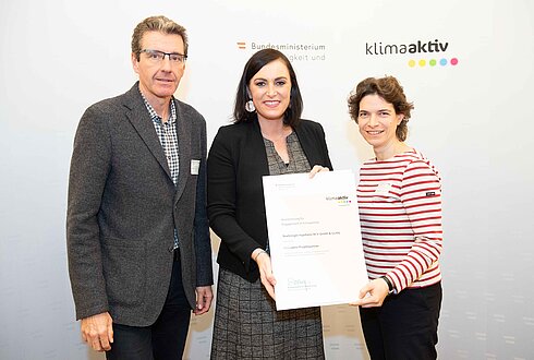 Ausgezeichneter Betrieb und bestehender Projektpartner: Boehringer Ingelheim RCV GmbH & Co KG v.l.n.r. Christian Seidel (Infrastruktur/Betriebsingenieur Medien), Bundesministerin Elisabeth Köstinger, Natalie Egreteau (Energiemanagerin)