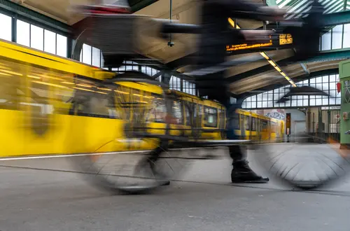 Fahrrad wird am Bahnhof geschoben.