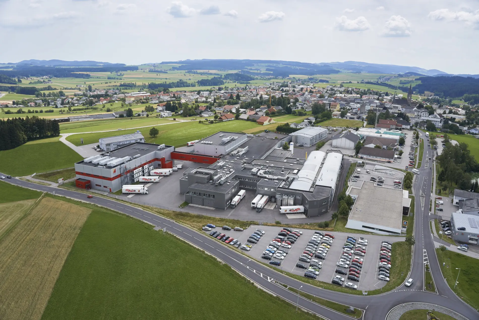 Firmengelände Hochreiter Bad Leonfelden. Panoramaansicht mit Dorf und Hügeln im Hintergrund