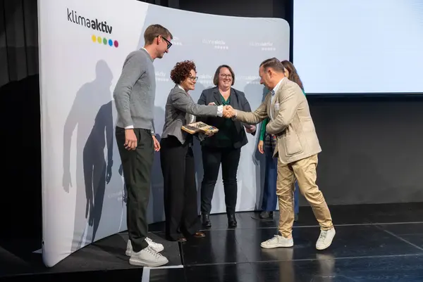 Personen auf einer Bühne gratulieren sich, schütteln Hände