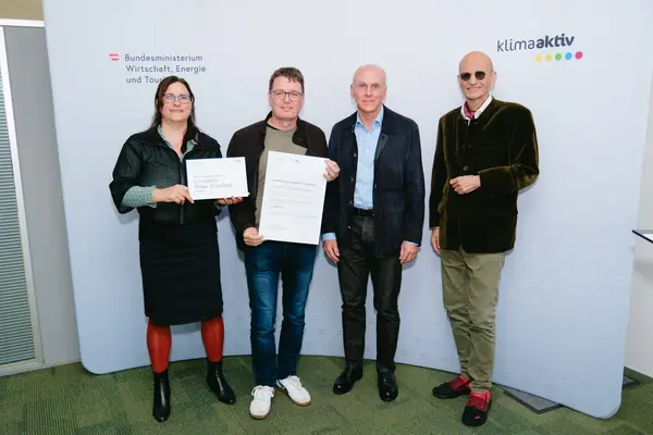 Personen mit Urkunden schauen in die Kamera