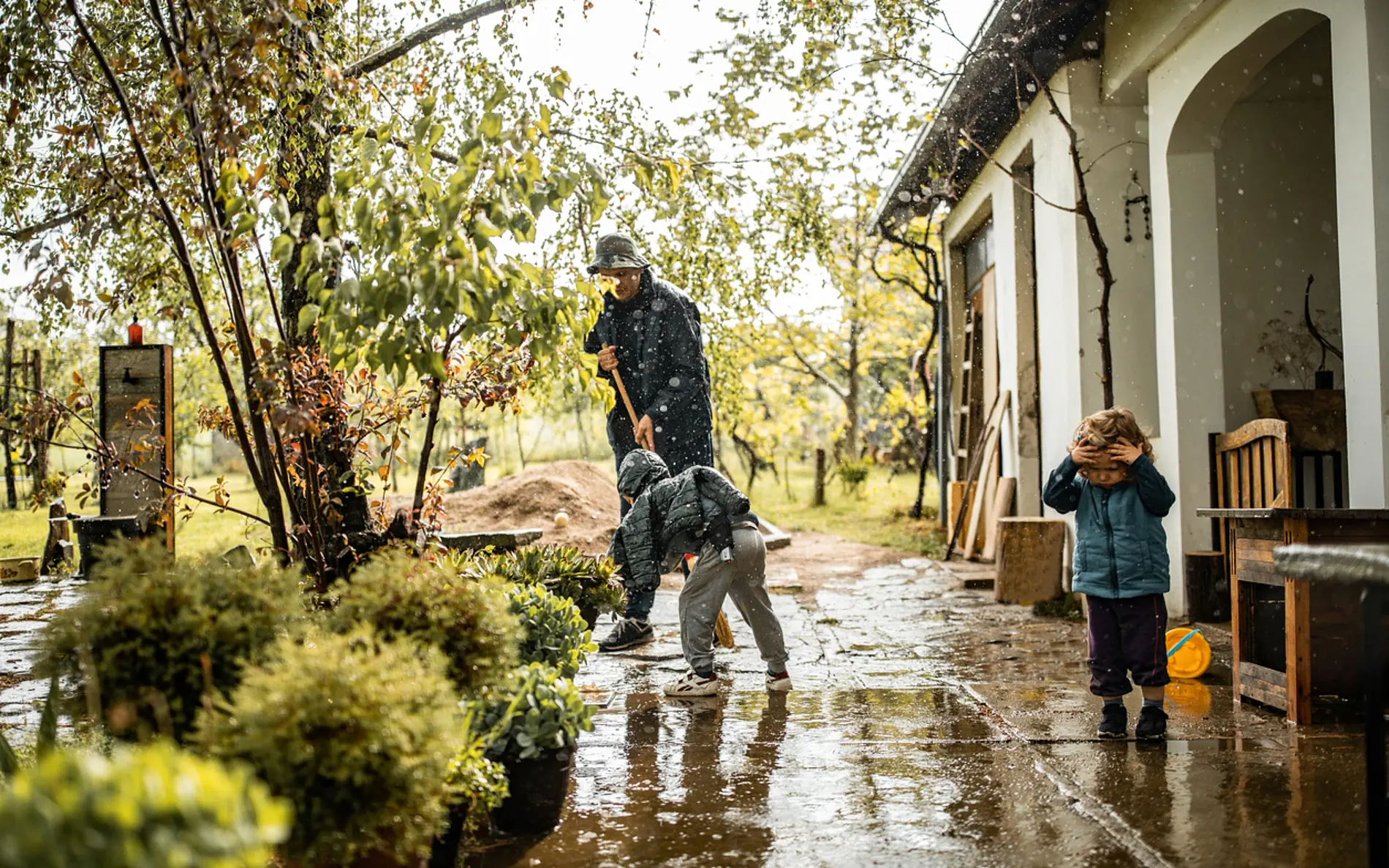 EIn vater und sein junger Sohn wischen zusammen die unterwasserstehende Terrasse