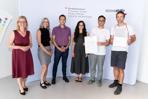 Im Bild: Klimaschutzministerin Leonore Gewessler, Giulia Gelmetti, Elisabeth Krammer und Peter Schwaiger (INNOCAD Architektur), Florian Grangl (IMMOVATE), Markus Kozak (Pilz & Partner ZT)