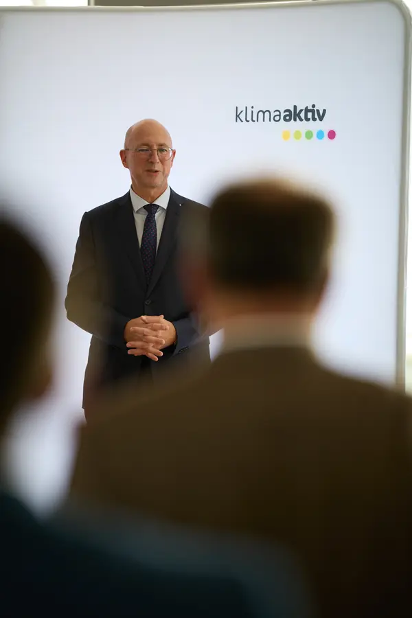 ein Mann im Anzug spricht vor einem Publikum