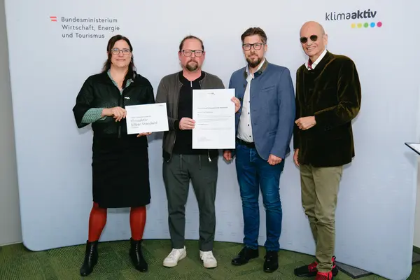 Personen mit Urkunden schauen in die Kamera