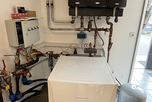Technikraum mit Heizungs- und Rohrsystem, Steuerungseinheit und Speicher.