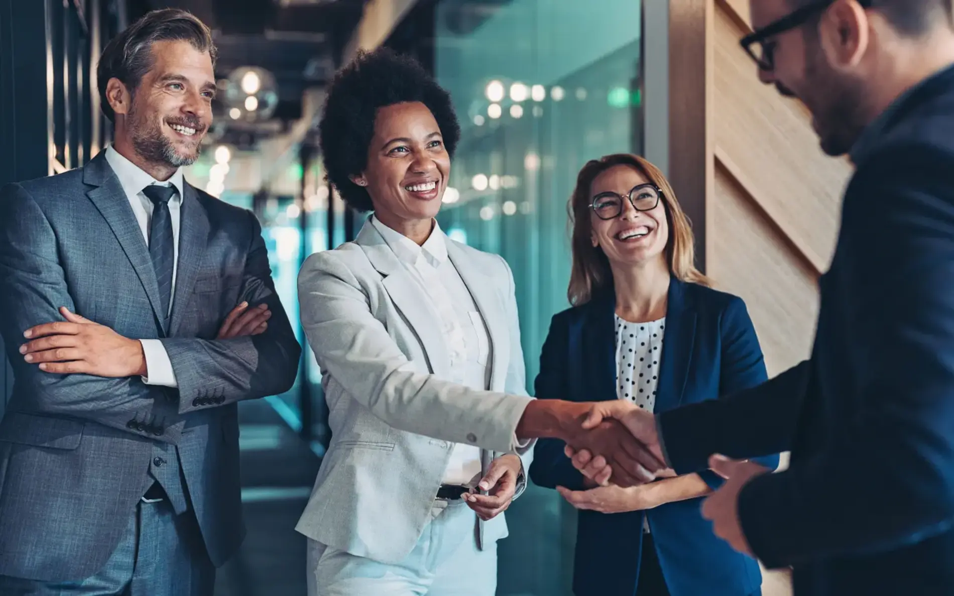 Personen lächeln und geben sich zum Vertragsabschluss die Hand