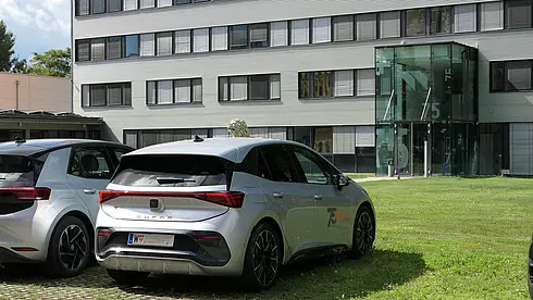 Mehrere Autos parken vor dem Eingang des Werner Consult Bürogebäudes mit der Hausnummer 75.