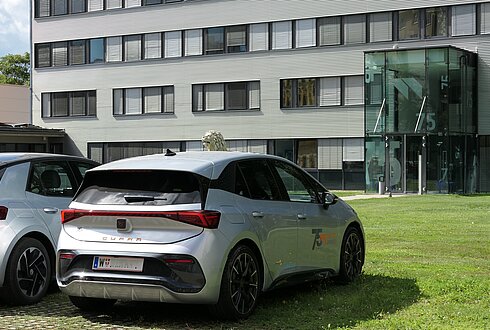 Mehrere Autos parken vor dem Eingang des Werner Consult Bürogebäudes mit der Hausnummer 75.