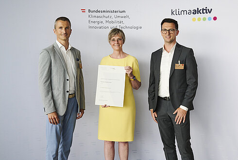 Im Bild: Thomas Gittler (Leiter Integrierte Managementsysteme), Mirsad Muric (Prokurist, Technology & Lean Management) mit Bettina Bergauer (BMK)