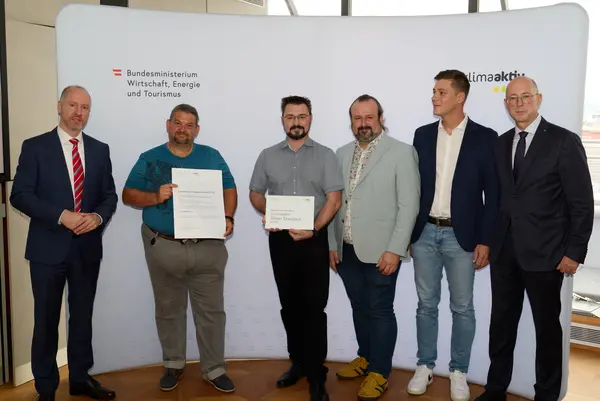 6 Personen mit Urkunde schauen in die Kamera