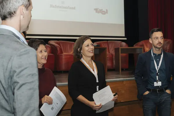 Mehrere Personen mit Urkunden und Karten in der Hand