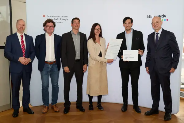 6 Personen mit Urkunde schauen in die Kamera