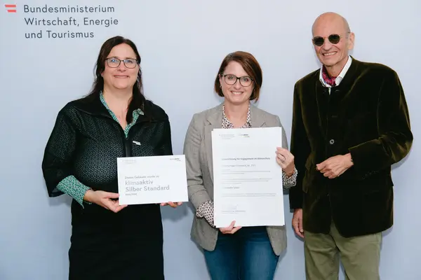 Personen mit Urkunden schauen in die Kamera