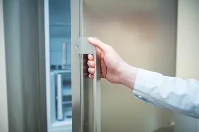 Ein Mann öffnet einen Kühlschrank.