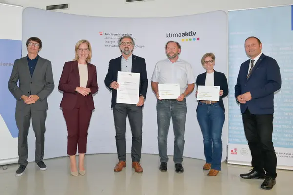 Im Bild: Klimaschutzministerin Leonore Gewessler, LHStv. Josef Geisler, DI Robert Taunmüller (Energie Tirol), Ing. Ferdinand Jenewein und DI (FH) Thomas Hackl (TIGEWOSI, TIROLER GEMEINNÜTZIGE WOHNUNGSBAU- UND SIEDLUNGS GES.M.B.H.), DI Christina Krimbacher
