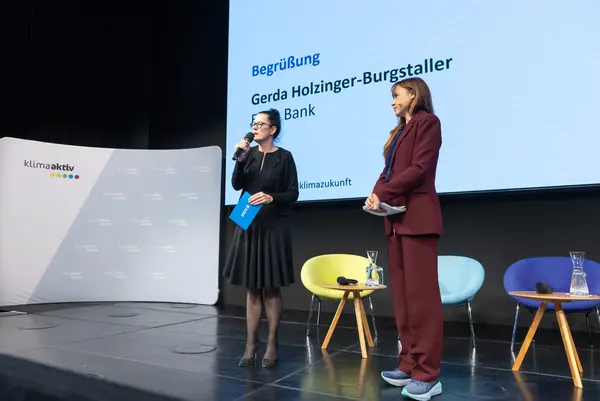 Frau auf einer Bühne spricht ins Mikro