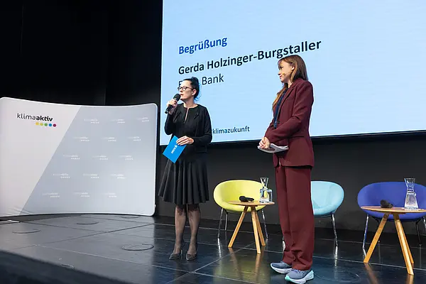 Frau auf einer Bühne spricht ins Mikro