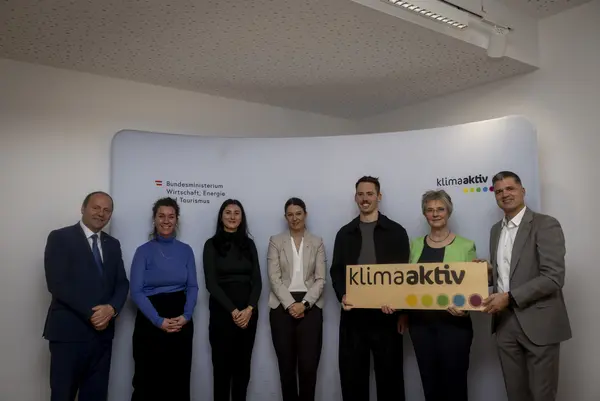 mehrere Personen mit Urkunde in der Hand schauen in die Kamera