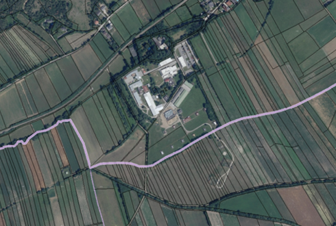 Luftaufnahme des Astotec Pyrotechnic Solution GmbH Standorts in Winzendorf, Niederösterreich. Mehrere Hallen und Zufahrtswege sowie regelmäßig angeordnete Feldflächen sind aus der Vogelperspektive zu sehen.