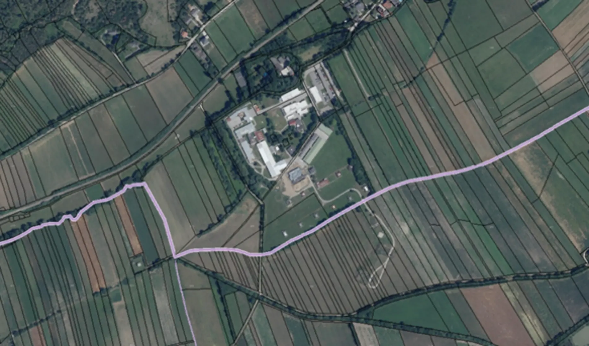 Luftaufnahme des Astotec Pyrotechnic Solution GmbH Standorts in Winzendorf, Niederösterreich. Mehrere Hallen und Zufahrtswege sowie regelmäßig angeordnete Feldflächen sind aus der Vogelperspektive zu sehen.