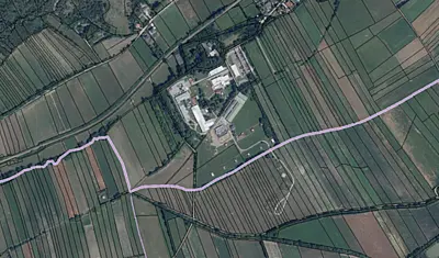 Luftaufnahme des Astotec Pyrotechnic Solution GmbH Standorts in Winzendorf, Niederösterreich. Mehrere Hallen und Zufahrtswege sowie regelmäßig angeordnete Feldflächen sind aus der Vogelperspektive zu sehen.