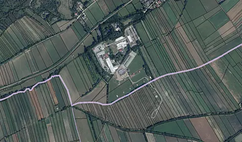 Luftaufnahme des Astotec Pyrotechnic Solution GmbH Standorts in Winzendorf, Niederösterreich. Mehrere Hallen und Zufahrtswege sowie regelmäßig angeordnete Feldflächen sind aus der Vogelperspektive zu sehen.