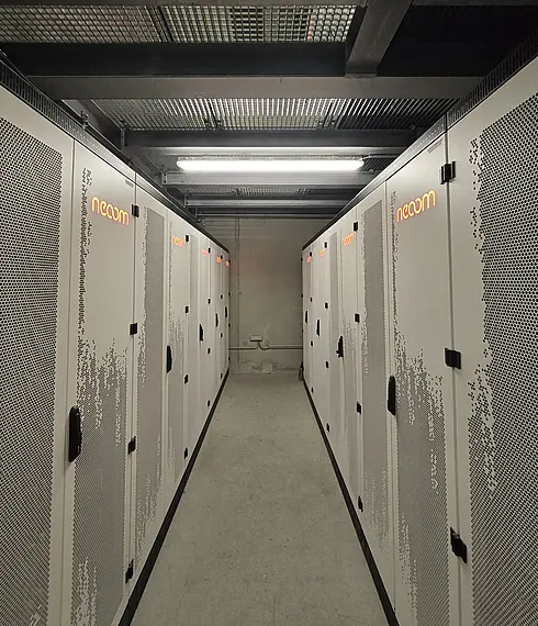 Raum mit mehreren geschlossenen Batteriespeicher-Schränken in zwei Reihen, industrielle Installation für Energiespeicherung.