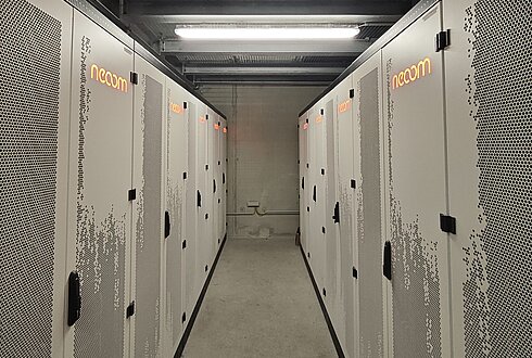 Raum mit mehreren geschlossenen Batteriespeicher-Schränken in zwei Reihen, industrielle Installation für Energiespeicherung.