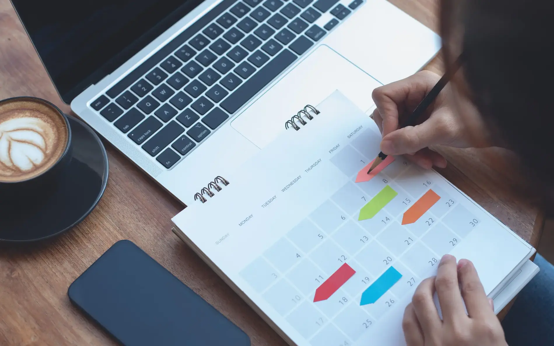 Person schreibt etwas in einen Kalender