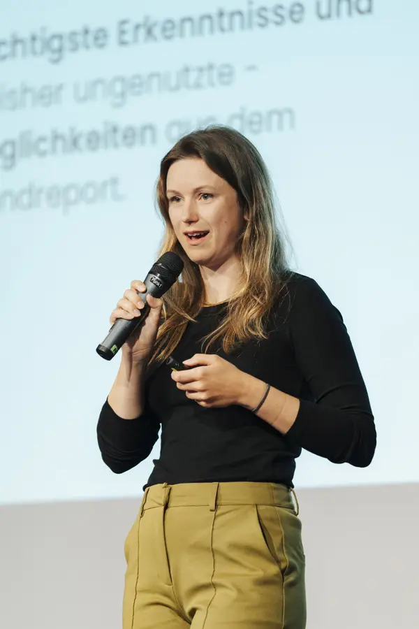 Frau mit Mikro auf der Bühne