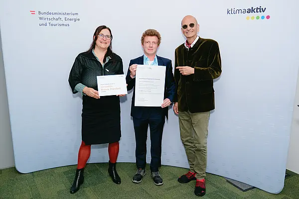 Personen mit Urkunden schauen in die Kamera
