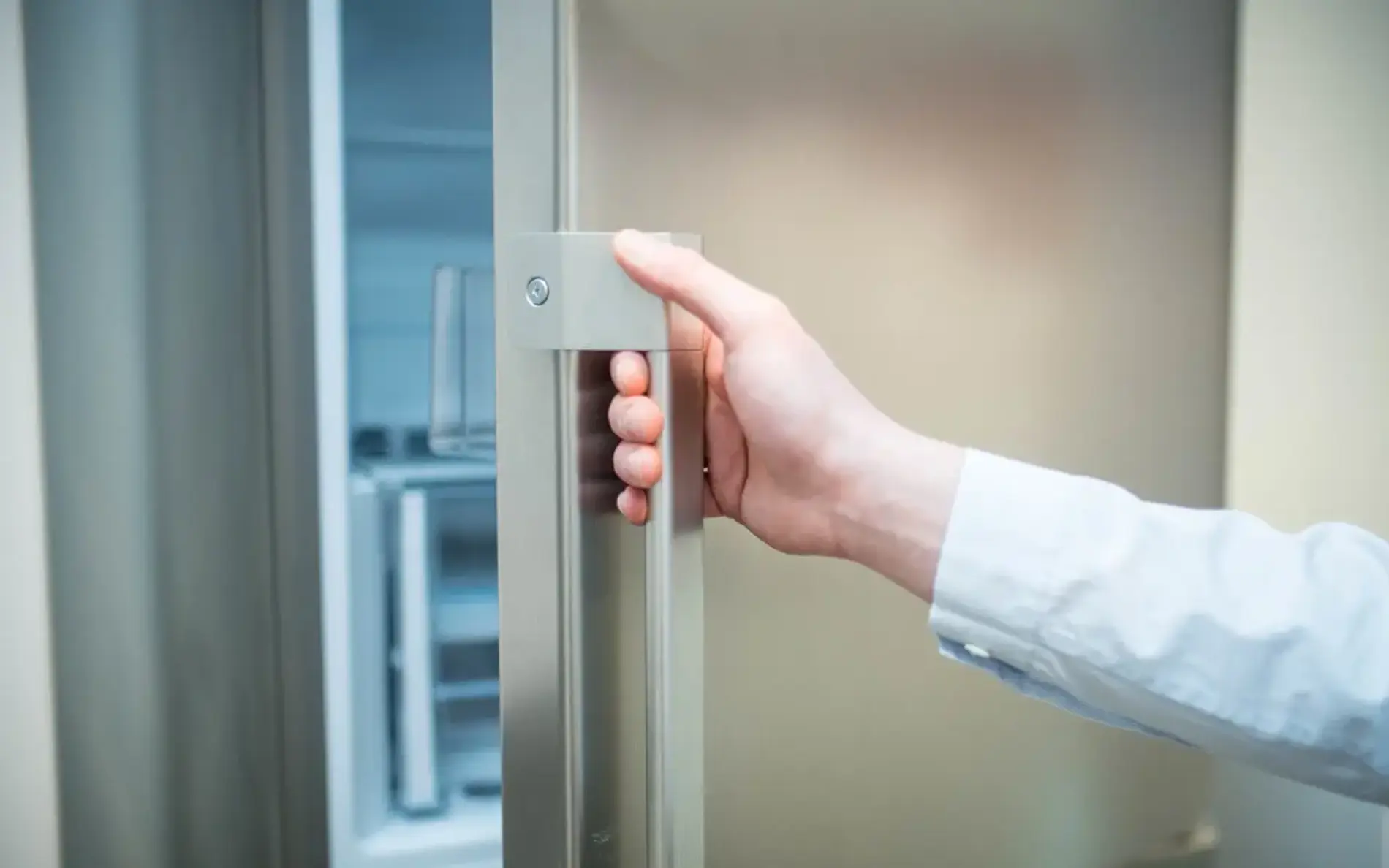 Ein Mann öffnet einen Kühlschrank.