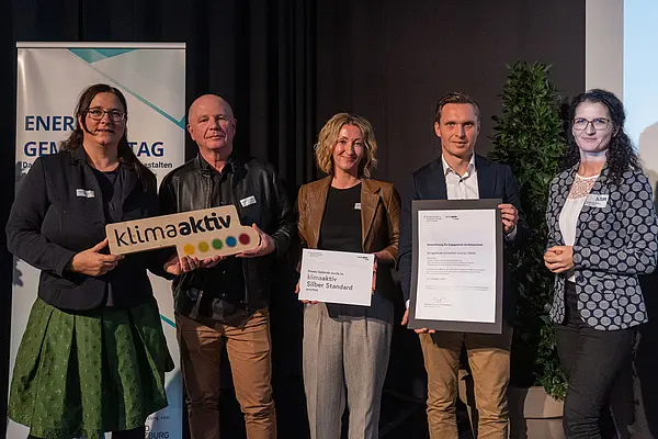 Personen mit Urkunden schauen in die Kamera