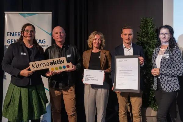 Personen mit Urkunden schauen in die Kamera