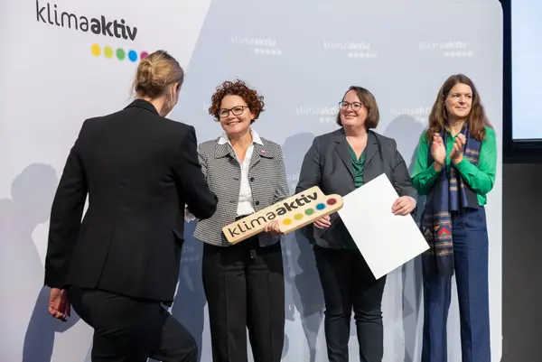 Personen auf einer Bühne gratulieren sich, schütteln Hände