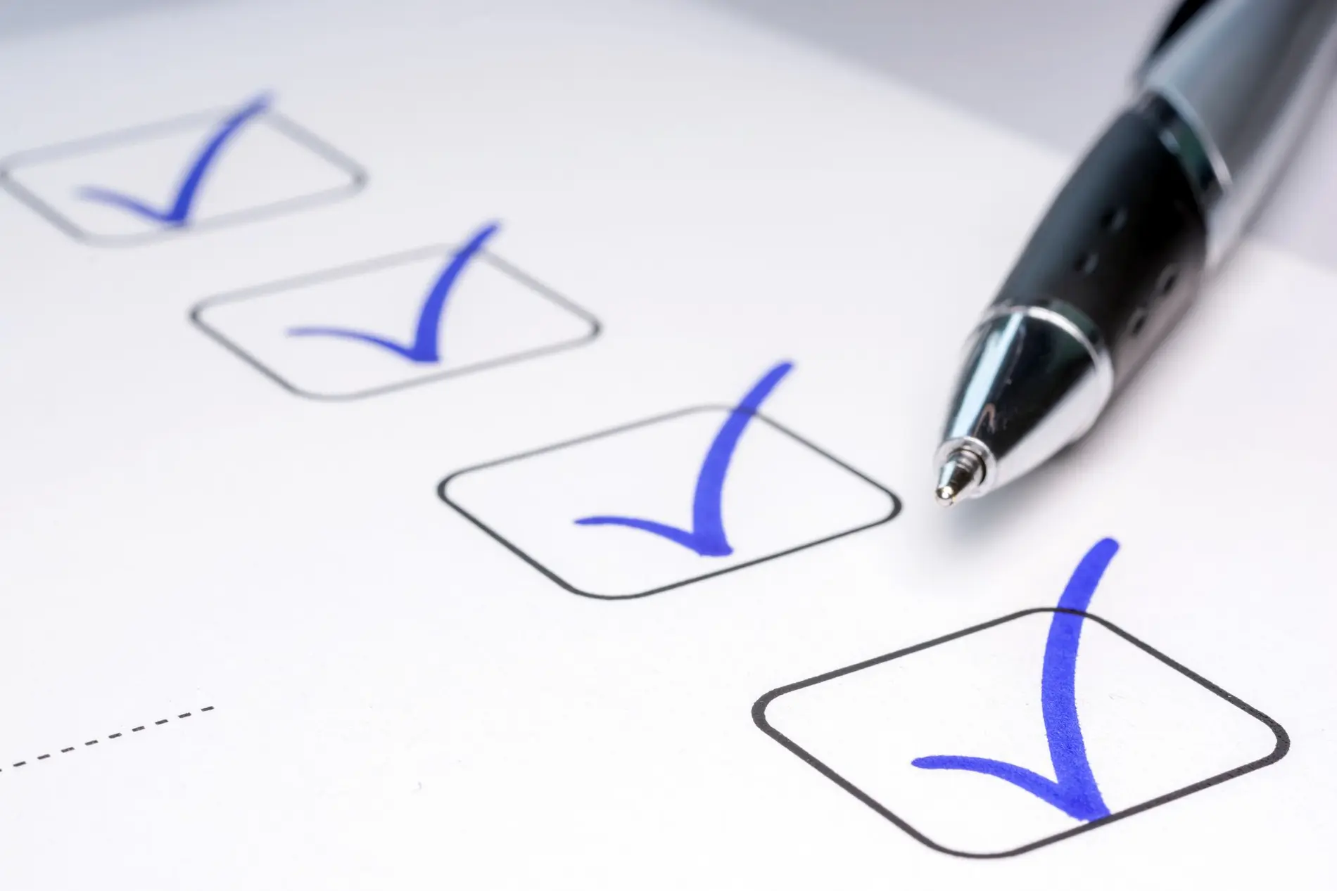 Checkliste mit Checkboxen und Kugelschreiber