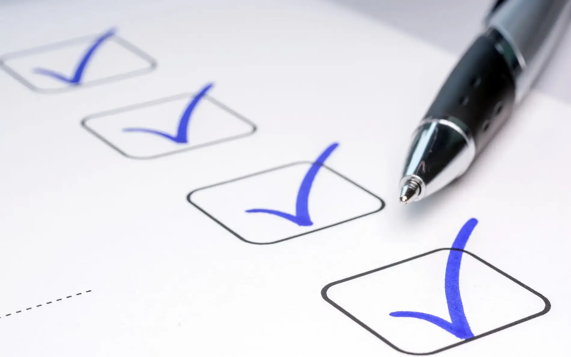 Checkliste mit Checkboxen und Kugelschreiber