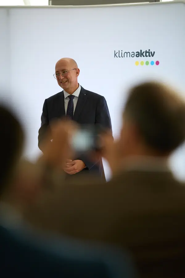 ein Mann im Anzug spricht vor einem Publikum