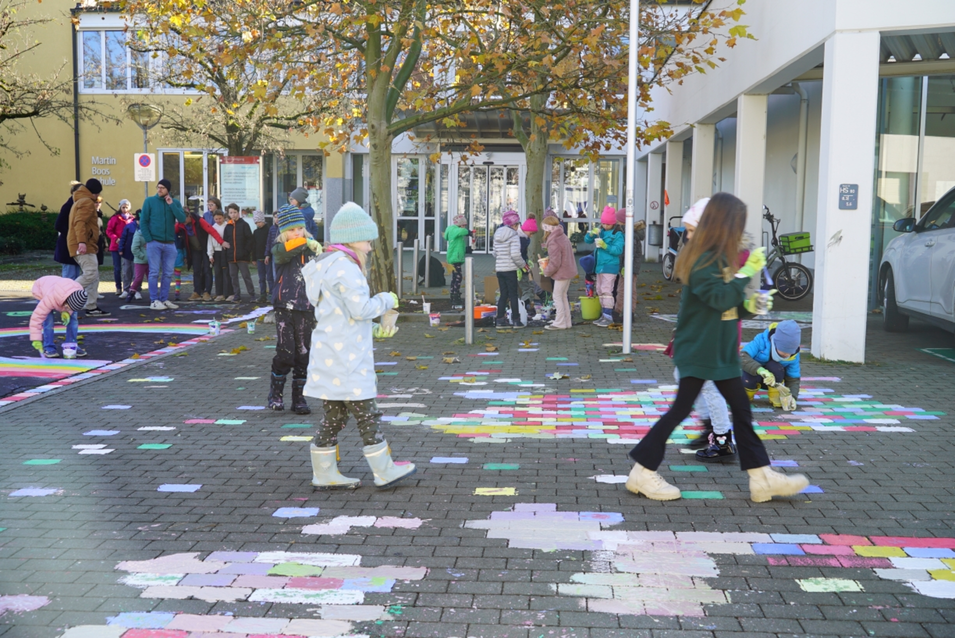 viele Kinder bemalen Pflastersteine bunt