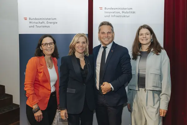 Vier Personen posieren vor Rollup